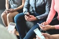 Group of millennial business people using mobile phones and sitting on couch. Networking and teamwork. Working on project. Royalty Free Stock Photo