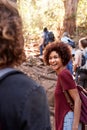 Group of millennial friends hiking up hill on a forest trail, vertical