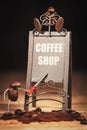 Group of miniature figures of coffee beans, around a rusty restaurant sign Royalty Free Stock Photo