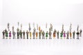 Group of miniature people over white background standing in line