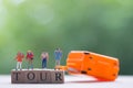 Group miniature traveler and hiker backpack standing on wooden text TOUR with suitcase