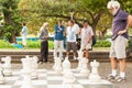 Group mixed age men standing around large outdoor set set interacting and considering next move