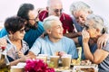 Group of mixed generations ages of people have fun together during pizza lunch - teenager adult and senior men and women smile and