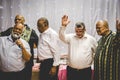 Group of mixed race men praying together