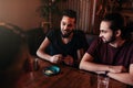 Group of mixed race young men talking and laughing in lounge bar. Multiracial friends having fun in cafe. Guys hangout Royalty Free Stock Photo