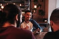 Group of mixed race young men talking and laughing in lounge bar. Multiracial friends having fun in cafe Royalty Free Stock Photo