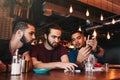 Group of mixed race young men talking in lounge bar. Multiracial friends having fun in cafe. Guys hanging out Royalty Free Stock Photo