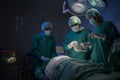 Group of mixed-races professional surgeons operating in hospital operating room , health care concept