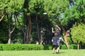 Group of mixed young teenagers people in casual wear playing with plastic flying disc game in a park oudoors. jumping man catch a