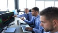 Group of modern business men in formalwear analyzing stock market data while working in the office Royalty Free Stock Photo