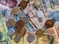 Group of money stack of banknotes from all over the world with some coins on top.