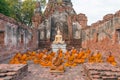 Group of monks sitting in ruined building of Wat Choeng Tha Temple