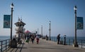 A group of mostly masked people walks on the Huntington Beach pier on Thanksgiving Day