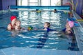 Group of mothers with little babies in children`s swimming section with coach. Healthy lifestyle