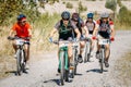 Group of mountain bike cyclists riding sandy track at sunny summer day, healthy lifestyle active athlete doing sport.