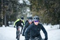 Group of mountain bikers riding on road outdoors in winter. Royalty Free Stock Photo