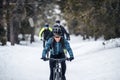 Group of mountain bikers riding on road outdoors in winter. Royalty Free Stock Photo