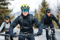 Group of mountain bikers riding on road outdoors in winter. Royalty Free Stock Photo