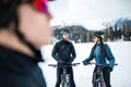 Group of mountain bikers standing on road outdoors in winter. Royalty Free Stock Photo