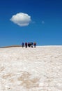 Group of mountain climbers walking on snow with white cloud in sky
