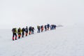 Group of mountaineers climbing in the snowy mountain peaks.