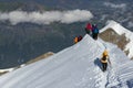 A group of mountaineers climbs to the top of a snow-capped mountain Royalty Free Stock Photo