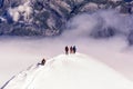 A group of mountaineers climbs to the top of a snow-capped mountain Royalty Free Stock Photo