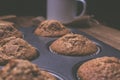 Group of muffins inside the baking tin on a wooden table Royalty Free Stock Photo