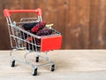 Group of mulberries in red shopping cart on wooden table. Mulberry this a fruit and can be eaten in have a red and purple color. M Royalty Free Stock Photo