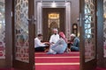 Group of muliethnic religious muslim young people praying an dreading Koran together. Group of muslims praying in the mosque
