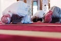 Group of muliethnic religious muslim young people praying and reading Koran together. Group of muslims praying in the mosque