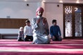 Group of muliethnic religious muslim young people praying and reading Koran together. Group of muslims praying in the mosque