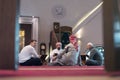 Group of muliethnic religious muslim young people praying and reading Koran together inside beautiful modern mosque