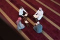 Group of muliethnic religious muslim young people praying and reading Koran together. Group of muslims praying in the mosque