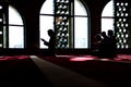 Group of muliethnic religious muslim young people praying and reading Koran together. Group of muslims praying in the mosque