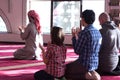 Group of muliethnic religious muslim young people praying and reading Koran together. Group of muslims praying in the mosque