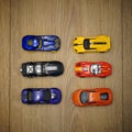 Group of multi-color toy cars on a wooden surface