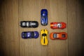 Group of multi-color toy cars on a wooden surface