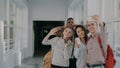 Group of multi-ethnic students taking selfie on smartphone camera while standing in corridor of university . Hipster guy Royalty Free Stock Photo