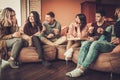 Group of multi ethnic young friends eating pizza in home interior Royalty Free Stock Photo