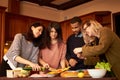 Group of multi ethnic young friends in kitchen prepare for party