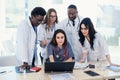 Group of multi national doctors using laptop for discussing analysis in the conference room. Side view. Royalty Free Stock Photo