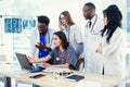 Group of multi national doctors using laptop for discussing analysis in the conference room. Side view. Royalty Free Stock Photo