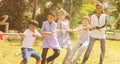 Group of multi racial children playing Tug of war game kindergarten - Multi ethnic kids playing outdoor games againt