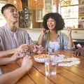 Group Of Multi-Racial Friends Sitting Around Table Playing Game Of Cards At Home Together Royalty Free Stock Photo