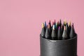 Group of multicoloured pencils black wooden in black paper round