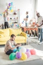 group of multicultural friends decorating room with party garlands