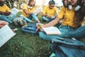 Group of multiethnic college students studying sitting on the grass - Happy teenagers having fun together at university campus - Royalty Free Stock Photo