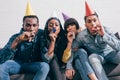 group of multiethnic friends in party hats celebrating