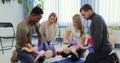 Group of multiethnic people during the first aid training with instructor showing on manikin how to do artificial Royalty Free Stock Photo